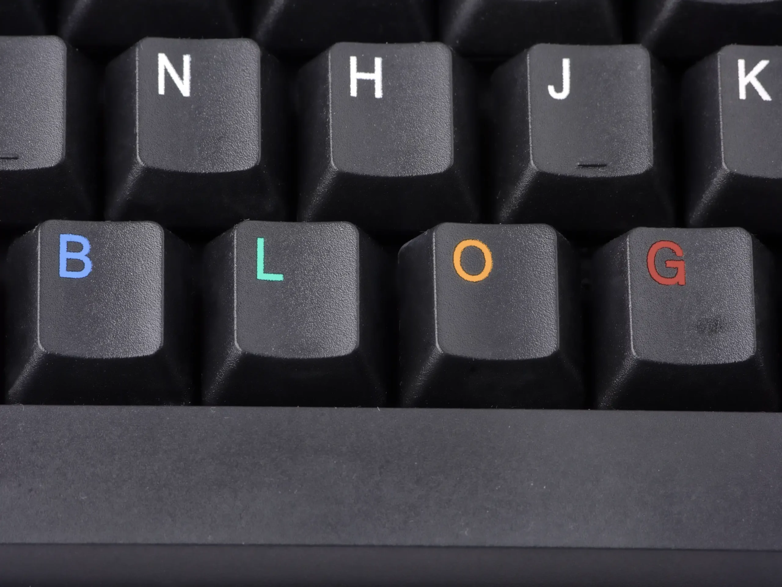 Teclado de computador com teclas personalizadas formando a palavra "BLOG".