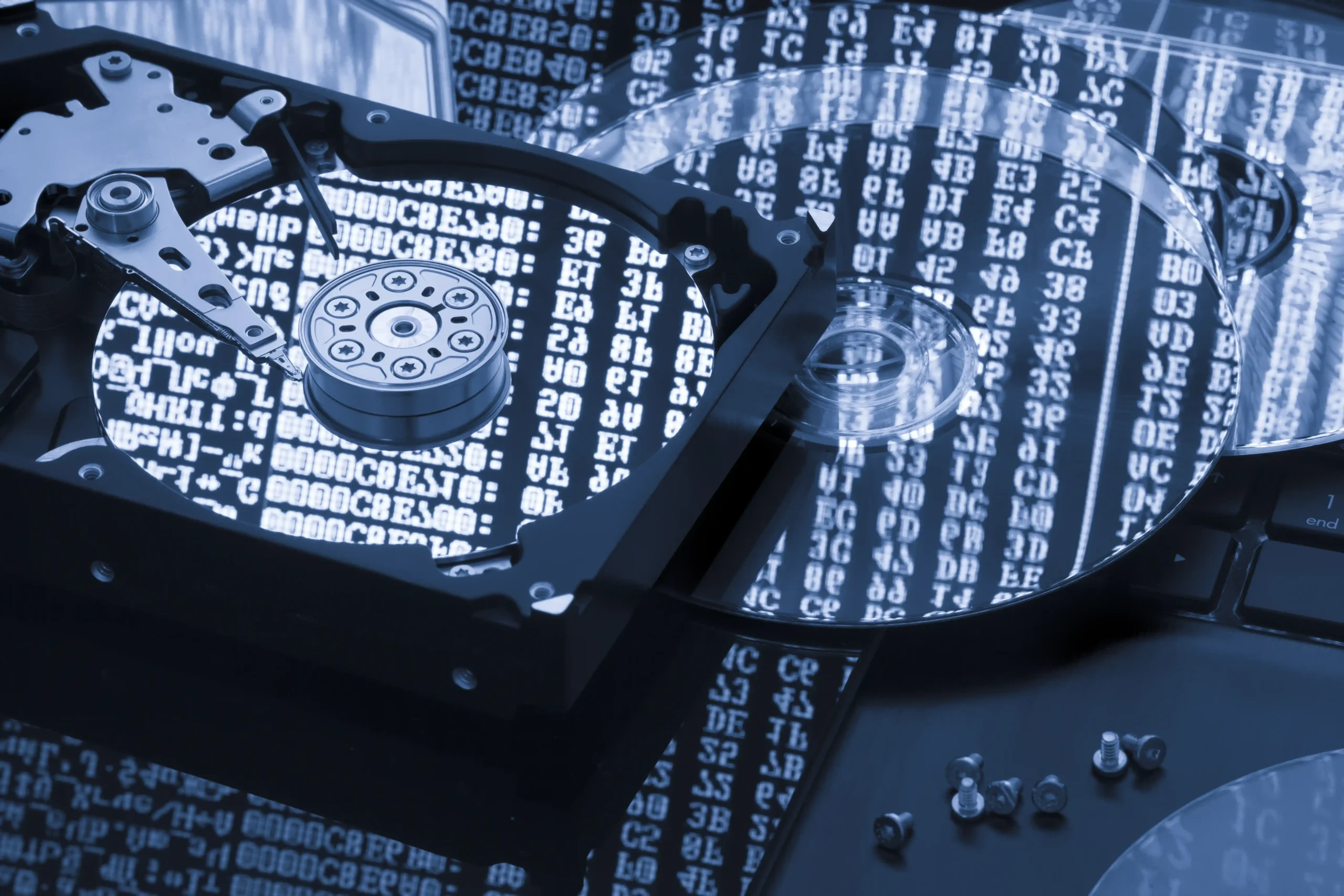 Disco rígido (HD) aberto com reflexo de códigos em hexadecimal, representando a importância das bases numéricas na computação e no armazenamento de dados.